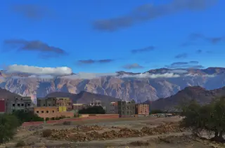 Panorama von Tafraout mit Bergen im Hintergrund, Wolken am Himmel und mehreren Gebäuden im Vordergrund